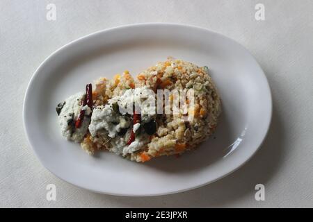 Dalia upma ou blé brisé upma est un petit-déjeuner indien du sud composé de blé brisé, de légumes de mélange et d'autres ingrédients de base de tempérament servis avec Banque D'Images