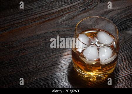 Verre de whisky avec glace blanche sur bois blanc tableau Banque D'Images