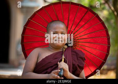 Portrait de moine débutant avec parapluie rouge, Bagan, région de Mandalay, Myanmar Banque D'Images