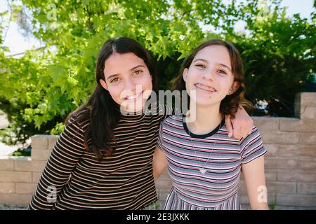 Teen et Tween Sisters portent des Stripes Smile pour la caméra Banque D'Images