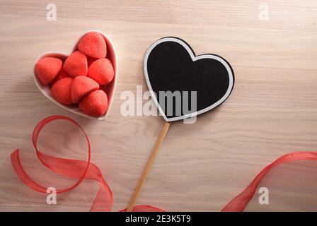 Affiche en forme de coeur et bonbons en gelée et sucre de fraise dans un contenant en forme de coeur. Vue de dessus. Banque D'Images