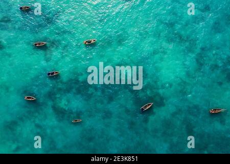 Photo aérienne des bateaux de pêcheurs flottant sur les vagues turquoise de l'océan Indien près de l'île de Zanzibar, en Tanzanie. Banque D'Images