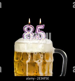 numéro 85 bougies dans la tasse à bière pour la fête d'anniversaire isolé sur le noir Banque D'Images