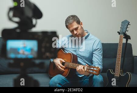 Homme avec guitare espagnole devant la caméra vidéo. Banque D'Images