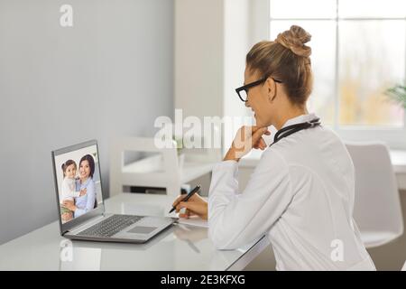 Femme médecin de famille donnant une consultation en ligne à une mère avec sa petite fille. Banque D'Images