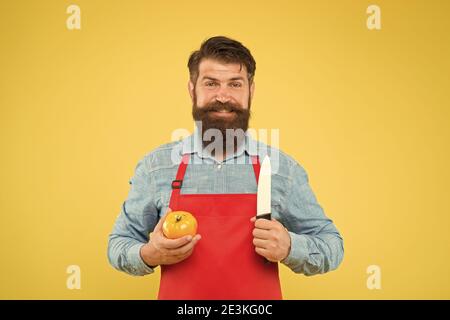 Recette de salade fraîche. Coupe sûre. Couper des légumes. Liste ultime des techniques de coupe que chaque chef devrait savoir. Le chef prépare le repas. Homme barbu préparer la tomate. Homme mature tient le couteau et le légume. Banque D'Images