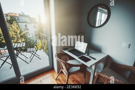 Vue d'un coin confortable dans un intérieur d'appartement avec un bureau d'un designer ou un espace de travail d'artiste numérique: Un ordinateur portable, concentrateur USB, téléphone portable, tablette graphique Banque D'Images
