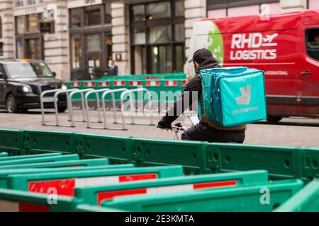 Un service de messagerie Deliveroo longe Piccadilly Circus pour livrer de la nourriture Takeaway dans le centre de Londres pendant le lockdown COVID-19. Banque D'Images