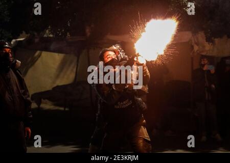 Tunis, Tunisie. 19 janvier 2021. Un officier de la garde nationale déclenche des gaz lacrymogènes contre les manifestants (non représentés sur la photo) lors d'affrontements dans la banlieue d'Ettadhamen, dans la banlieue nord-ouest de la capitale tunisienne, au milieu d'une vague de manifestations nocturnes ayant éclaté le 16 janvier. Credit: Khaled Nasraoui/dpa/Alay Live News Banque D'Images