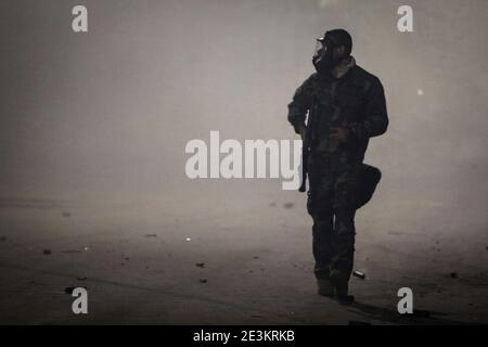 Tunis, Tunisie. 19 janvier 2021. Un officier de la garde nationale traverse un nuage de gaz lacrymogène lors d'affrontements dans la banlieue d'Ettadhamen, dans la banlieue nord-ouest de la capitale tunisienne, au milieu d'une vague de manifestations nocturnes ayant éclaté le 16 janvier. Credit: Khaled Nasraoui/dpa/Alay Live News Banque D'Images