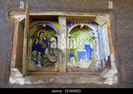 Une petite fausse fenêtre dans les murs en adobe de l'église Kidane Mehret sur le lac Tana, près de Bahir Dar, en Éthiopie, contient des peintures délicates de Marie et de Jésus. Banque D'Images