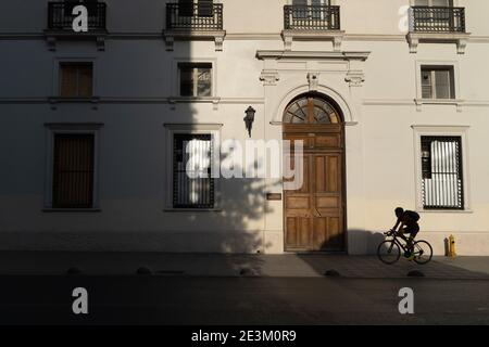 Santiago, Metropolitana, Chili. 19 janvier 2021. Un homme sur un vélo passe devant un vieux bâtiment dans le centre de Santiago, dans les dernières heures de la lumière du jour. Credit: Matias Basualdo/ZUMA Wire/Alamy Live News Banque D'Images