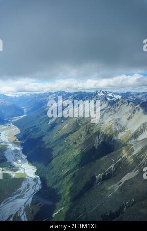 Vue aérienne sur les montagnes et la rivière tressée dans le paysage de Canterbury à travers la voûte perspex depuis l'intérieur du poste de pilotage du planeur en vol Banque D'Images
