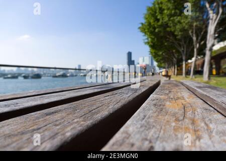 Kwun Tong Promenade à Hong Kong. Chaise en bois à gros plan avec arrière-plan flou Banque D'Images