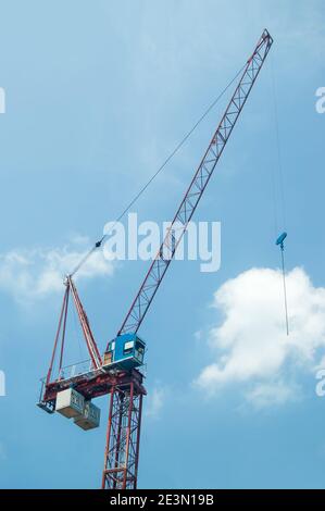 Grue à tour de construction avec flèche relevable contre le ciel bleu Banque D'Images