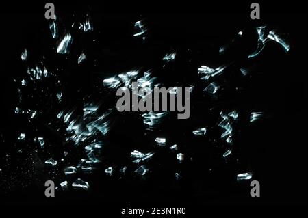 Morceaux de verre brisés et éclatés isolés sur le noir avec le mouvement Banque D'Images