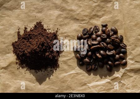 Grains de café et café moulu sur papier artisanal en dur lumière du soleil Banque D'Images