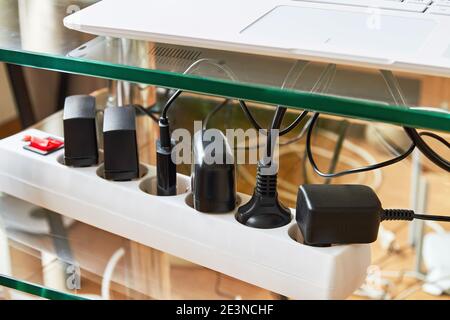 La barrette d'alimentation électrique est surchargée lorsque plusieurs cordons électriques sont branchés. De nombreuses fiches sont branchées sur la barre d'alimentation électrique. Banque D'Images