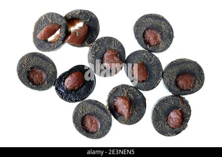 Morceaux de bonbons à la réglisse noire avec garniture au caramel. Isolé sur macro blanche Banque D'Images