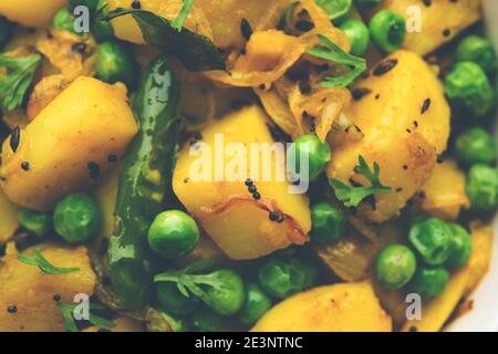 Aloo Mutter ou Matar aalu sabzi sec, pommes de terre indiennes et pois verts frits avec des épices et garni de feuilles de coriandre. Servi avec du roti ou Banque D'Images