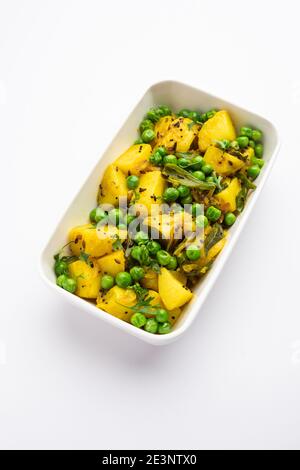 Aloo Mutter ou Matar aalu sabzi sec, pommes de terre indiennes et pois verts frits avec des épices et garni de feuilles de coriandre. Servi avec du roti ou Banque D'Images