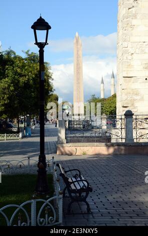 L'ancien hippodrome d'Istanbul avec l'obélisque de Theodosius derrière le banc et la lampe. Banque D'Images