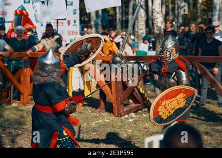 Combats entre femmes en armure. Deux femelles viking posant devant un groupe de guerriers. Festival de la culture médiévale. Combat par épée. Bichkek, Kirghizistan-13 octobre 2019. Banque D'Images