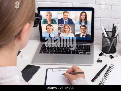 Femme d'affaires ayant une réunion virtuelle par appel vidéo assis sur le lieu de travail Banque D'Images