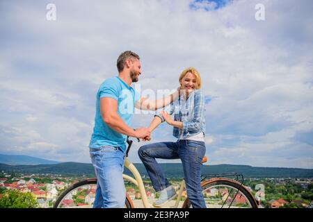 Homme avec barbe et dame blonde timide sur la première date. Comment satisfaire les filles alors qu'à vélo. Ramasser des fille. Couple tout juste de faire connaissance. Femme se sent timide en société avec macho attrayant. Banque D'Images