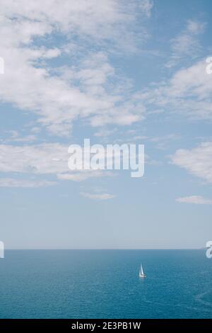 Concept de voyage fond - petit voilier dans la mer avec ciel bleu avec des nuages. Banque D'Images