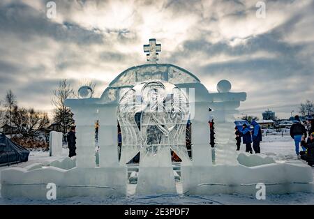 Police pour plonger dans un trou de glace pour le baptême de christ et de la sculpture sur glace sous la forme d'un ange et une croix Banque D'Images