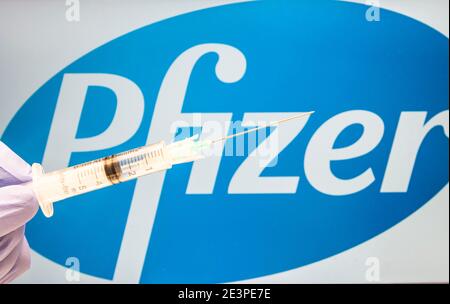 La seringue est un concept de vaccin COVID-19 avec le logo Pfizer en arrière-plan. Banque D'Images