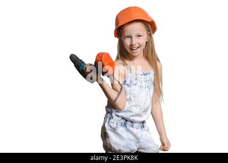 Petit ingénieur, petite fille portant le casque de construction, porte une perceuse électrique, isolée sur fond blanc. Banque D'Images