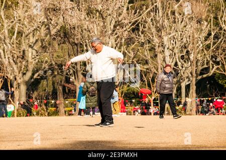 Un homme s'exerce à l'aide d'un yo-yo chinois dans le Fuxing Park de Shanghai. Banque D'Images