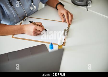 Personne effectuant une entrée dans un journal médical Banque D'Images