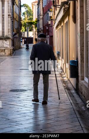 Homme âgé avec un bâton de marche dans la vieille ville, Zadar, Dalmatie, Croatie Banque D'Images