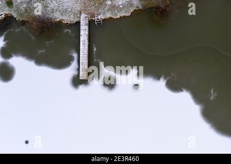 Photo aérienne d'un petit quai en bois sur un lac gelé Banque D'Images