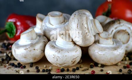 Tas de champignons crus, de poivrons et de tomates se trouvent sur une table en bois. format 16x9. Gros plan. Macro. Banque D'Images