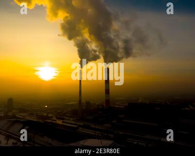 Émissions des centrales électriques vues au-dessus de la ville au lever du soleil. Pollution de l'environnement. Tuyau d'usine pour polluer l'air. Pipes fumeurs vue aérienne Banque D'Images