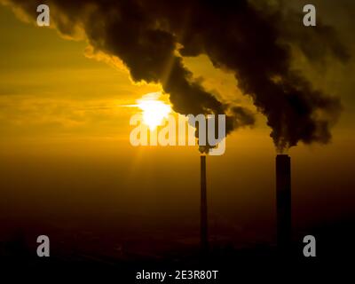 Émissions des centrales électriques vues au-dessus de la ville au lever du soleil. Pollution de l'environnement. Tuyau d'usine pour polluer l'air. Pipes fumeurs vue aérienne Banque D'Images