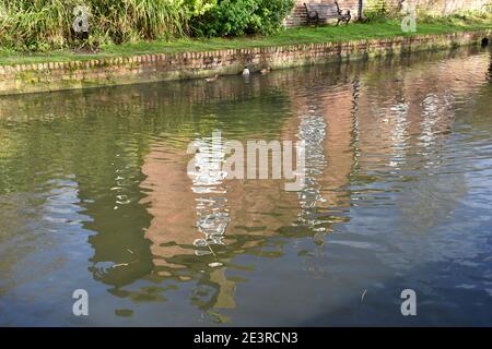 Reflet des réflexions d'un bâtiment en briques dans un canal par une journée ensoleillée au printemps. La maison se trouve au bord de l'eau Banque D'Images