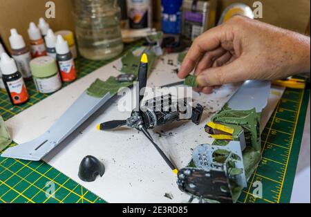 Homme construisant le moteur d'Airfix Spitfire modèle avion 1/24th in pèse-personne sur le bureau Banque D'Images