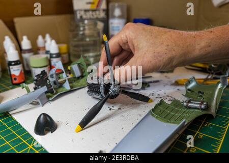 Homme construisant le moteur d'Airfix Spitfire modèle avion 1/24th in pèse-personne sur le bureau Banque D'Images