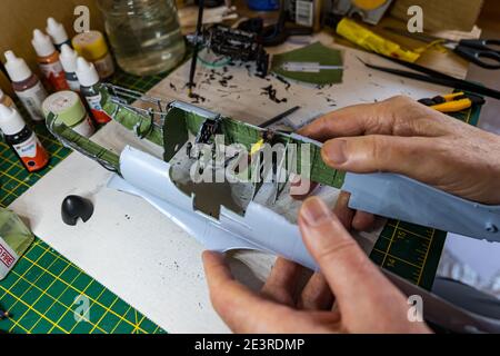 Homme construisant le moteur d'Airfix Spitfire modèle avion 1/24th in pèse-personne sur le bureau Banque D'Images