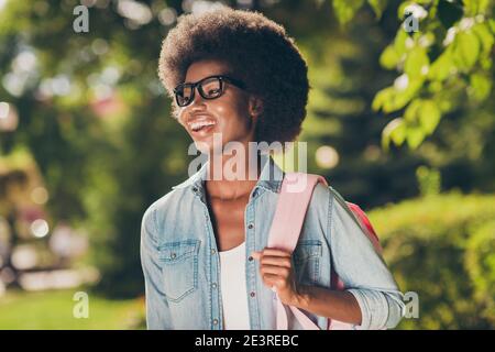 Photo portrait de jolie belle fille noire à la peau maure riant porter de manière gaieuse lunettes tendance jean chemise sac à dos Banque D'Images