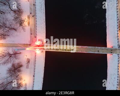 Vue sur le dessus du pont (Mist Zakokhanykh) de l'autre côté de la rivière dans le Skver Strilka illuminé dans le centre-ville de Kharkiv. Soirée aérienne d'hiver photo colorée Banque D'Images