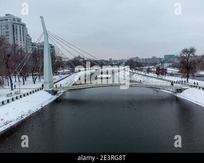 Passerelle piétonne traversant la rivière Kharkiv (Mist Zakokhanykh), lieu de prédilection des couples. Parc de loisirs du centre-ville aérien enneigé en hiver Banque D'Images