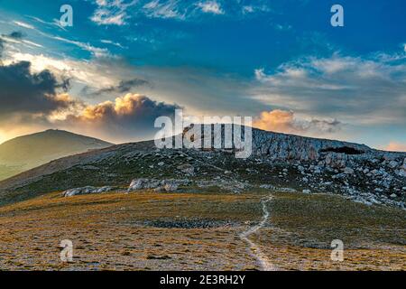 Monte Amaro, chemin vers le haut. Grotta Canosa et, en arrière-plan, le sommet de la Maiella. Parc national de Maiella, Abruzzes, Italie, Europe Banque D'Images