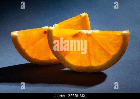 fruits orange tranchés sur fond bleu Banque D'Images