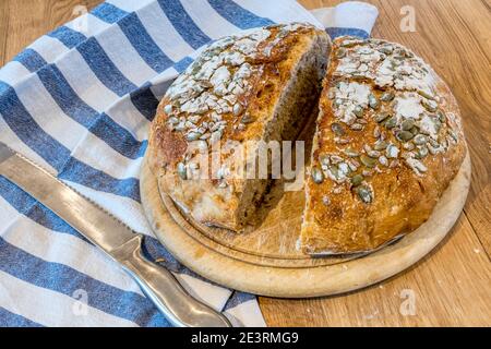 Pain de levain cuit maison, coupé sur une table de cuisine. Banque D'Images